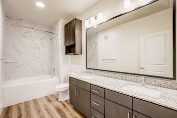 A bathroom with a marble patterned wall and a white toilet. at Aurora Watson Branch, Texas, 76063